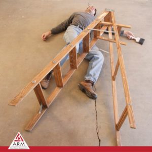 Image of a person in jeans and work boots on the floor with legs entangled in fallen ladder (image of a ladder fall accident) for ARM action resource management