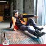 Image is about floor obstacles in the workplace, showing a young man worker wearing an orange safety vest on the ground as if he has fallen down - for A.R.M. action resource management Safety training