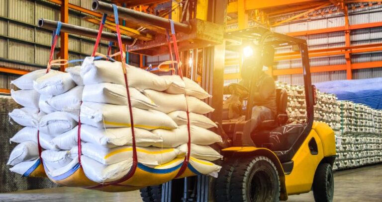 Image of a forklift operator driving large white packages in warehouse. Material and equipment handling. A.R.M. Action Resource Management