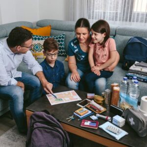 Image of a family reviewing their disaster preparedness kit. A.R.M. action resource management
