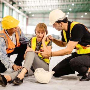 This is an image of three warehouse workers. Two men assisting a woman coworker who has had a seizure. A.R.M. Action Resource Management.