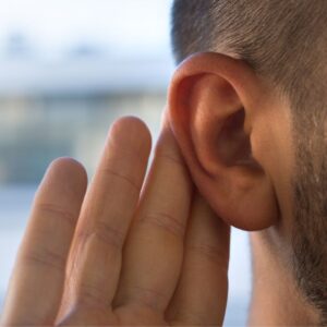 An image of a person holding their hand to their ear in order to hear better. Fo Hearing Loss - World Hearing Day, March 3, 2024.