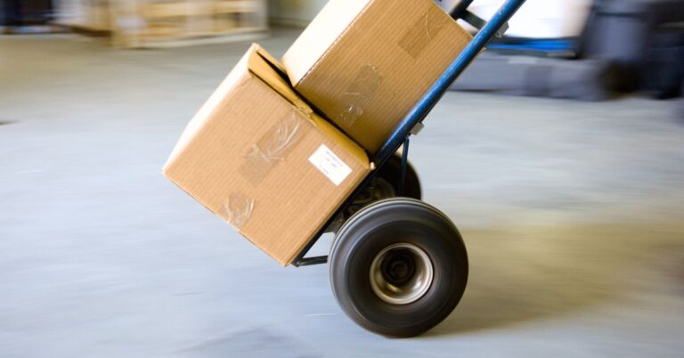 An image of a hand truck in use at a warehouse. Essential Hand Truck Safety Tips.