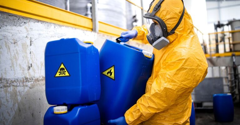 A worker storing hazardous materials in a warehouse.