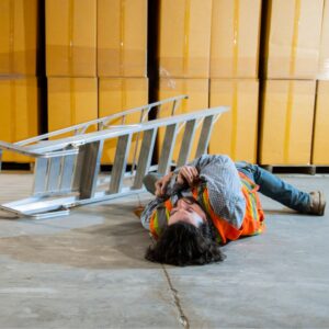 An image of a warehouse worker who has fallen off a ladder.