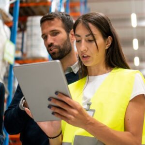 An image of a warehouse worker training a new employee. Preventing Workplace Injuries – Essential Safety Tips for Warehouse Staff