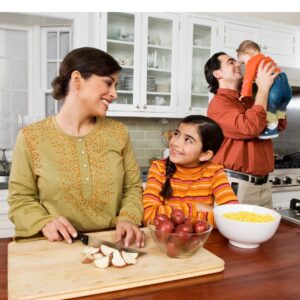 An image of a family of four in the kitchen together preparing a holiday meal.