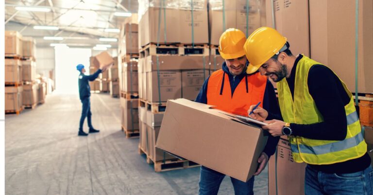 Warehouse workers reviewing shipment manifest on a clipboard. Warehouse Safety Best Practices: Ensuring a Safe Work Environment