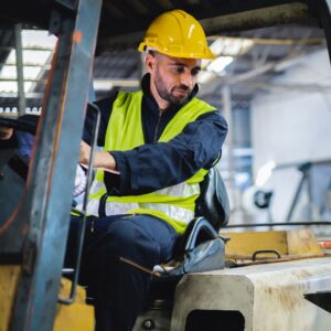 Warehouse safety shown as forklift driver looks over his shoulder