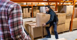 An image of a warehouse worker being trained to lift properly.