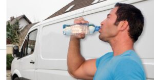A delivery driver drinking from a water bottle near his van. Delivery Drivers, Heat, and Hydration: Essential Tips