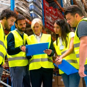 Group of warehouse workers meeting with manager to review safety tactics