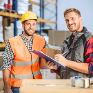 Smiling warehouse workers discuss shipments